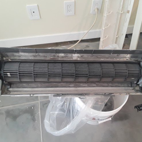 Technician inspecting AC components.